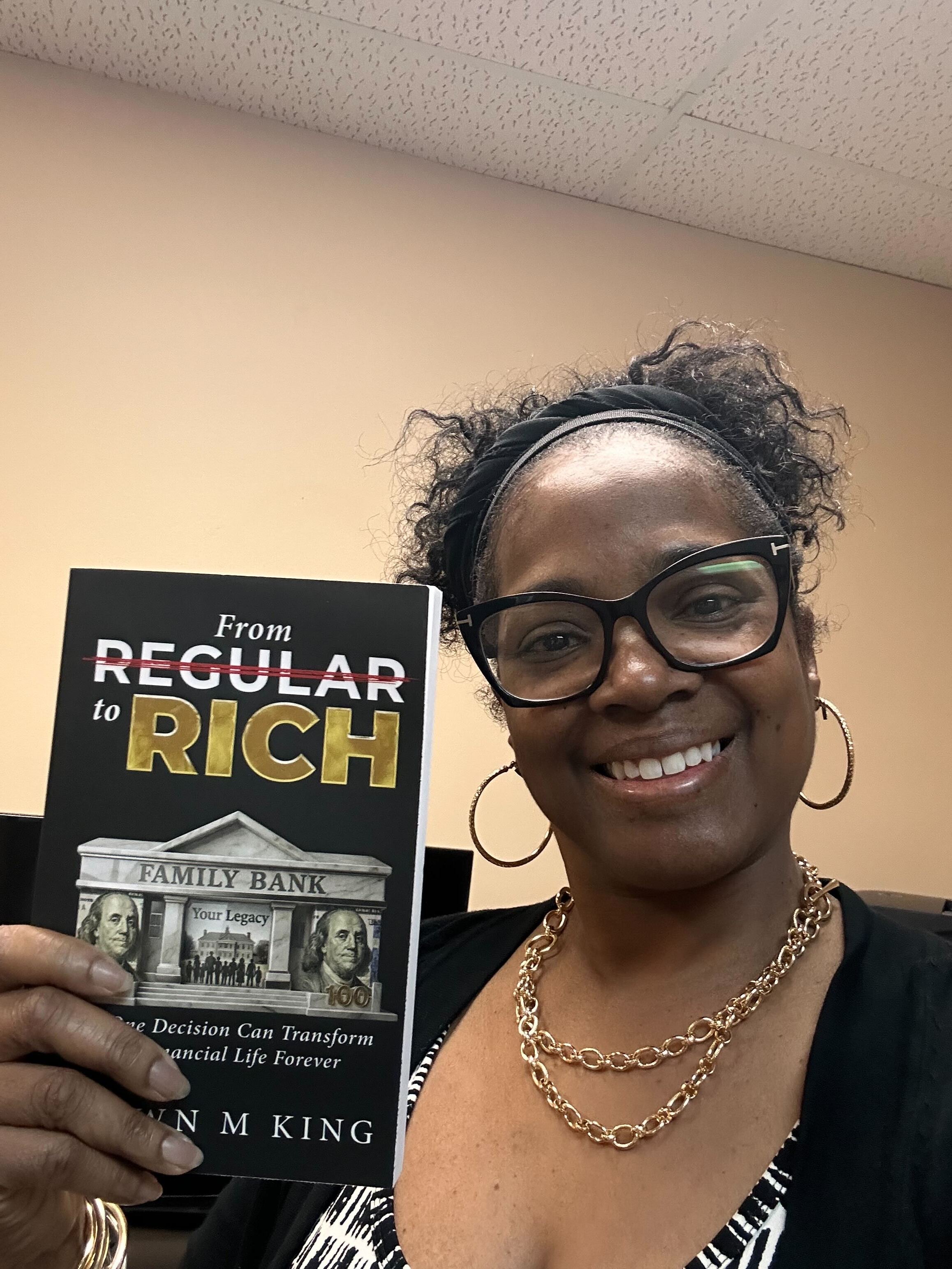Reader holding a copy of From Regular to Rich by Shawn King.